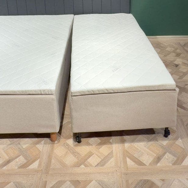 Cama de extensão com rodas encostada à cama, com as duas superfícies de descanso ao mesmo nível