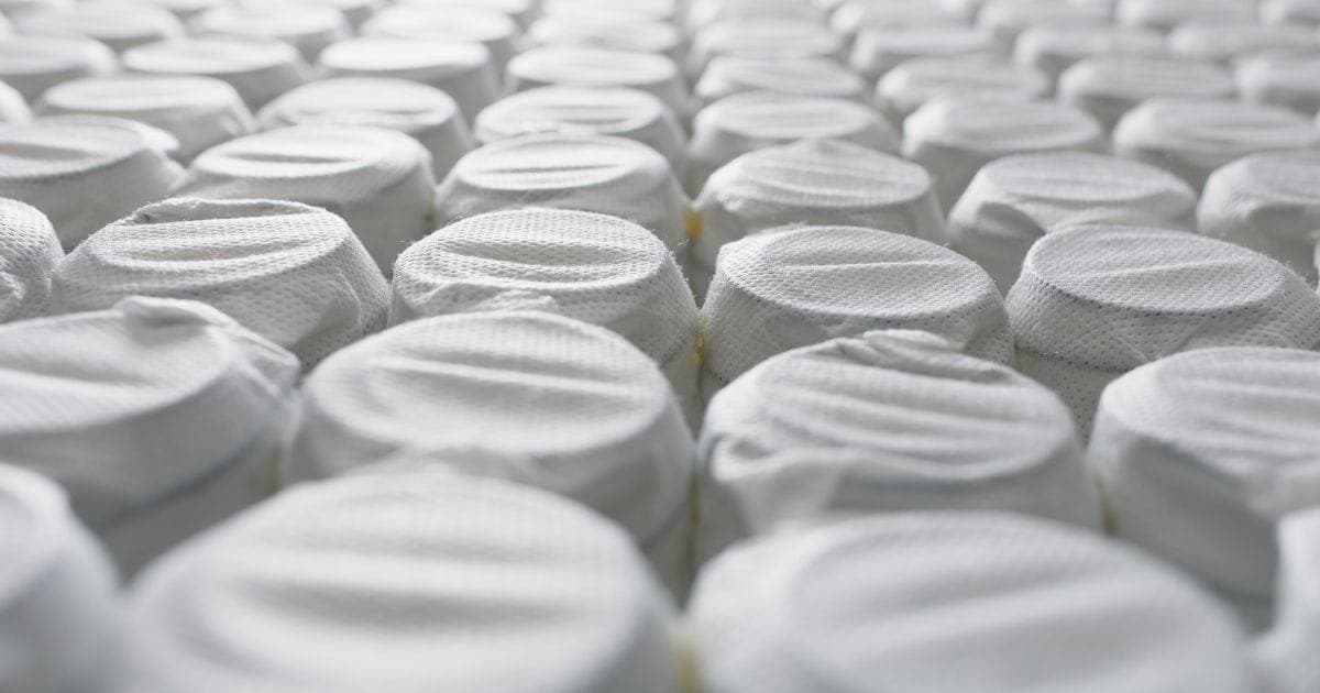 Grande plano de filas de molas ensacadas, cada uma cosida na sua própria bolsa de tecido