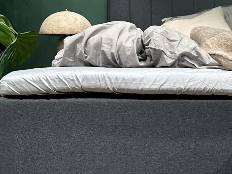Pormenor do lençol FamBed esticado sobre o sobrecolchão de uma cama familiar