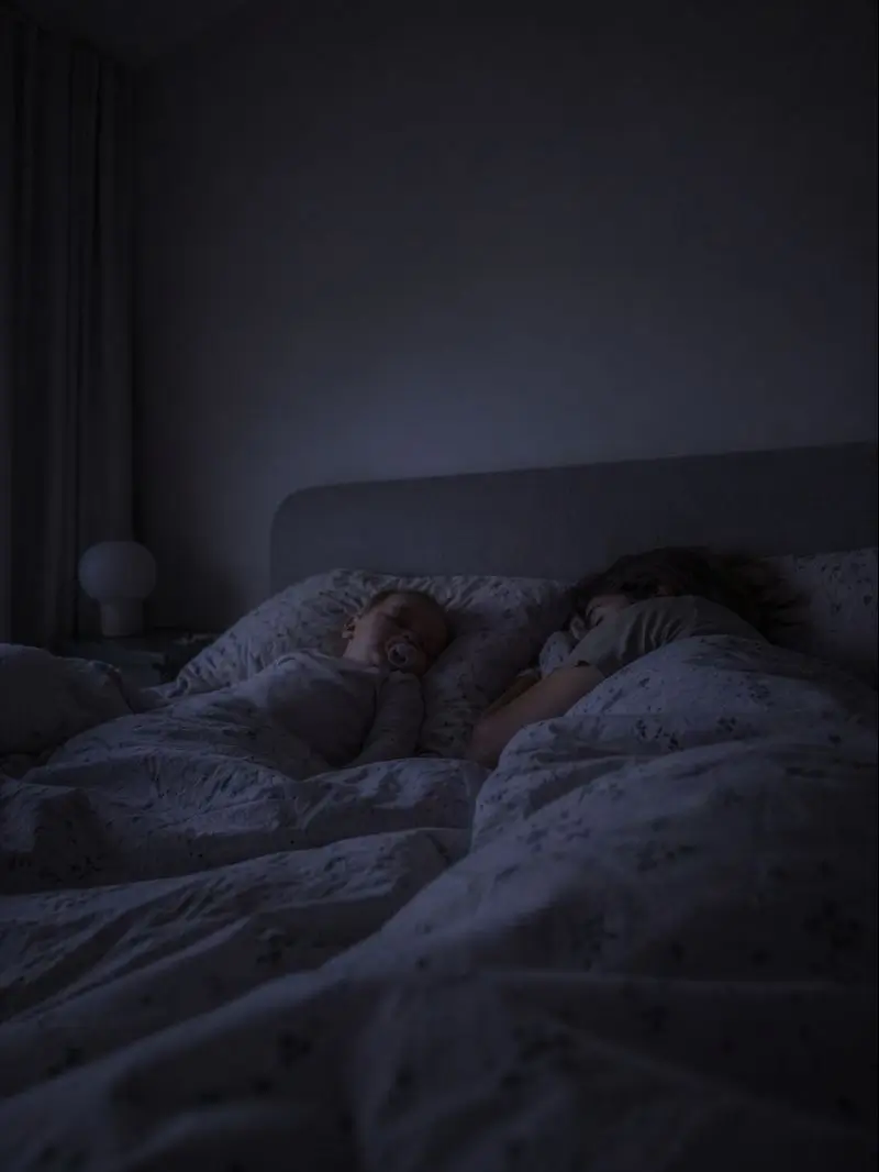 Pais e uma criança dormem juntos na cama, sob uma luz noturna suave
